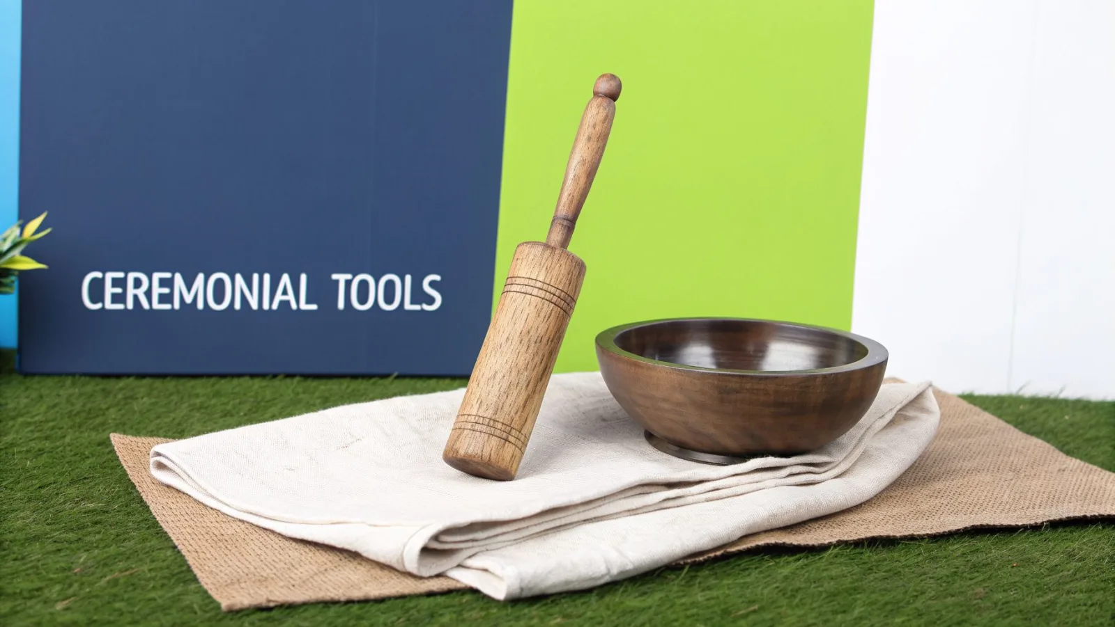 Ein hölzerner Stößel und eine Mörserschale auf Naturstoffen, mit einem Schild „Ceremonial Tools“.